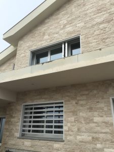 Grata a scomparsa bianca su facciata in travertino, formato verticale